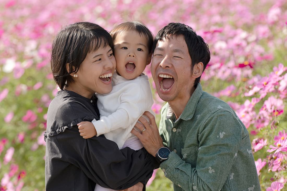 家族写真の出張撮影｜コスモスの花をバックに、みんなで大きな口を開けての家族写真