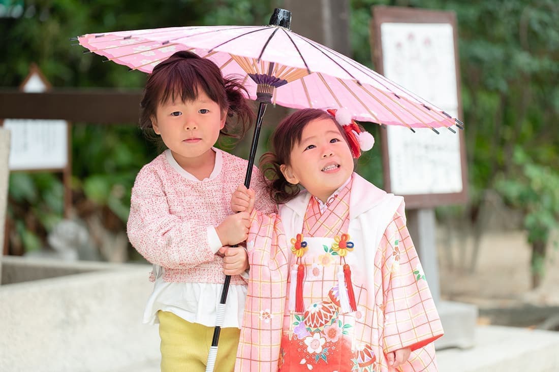 七五三の出張撮影|ピンク色の和傘に入った姉妹。とっても嬉しそうです。